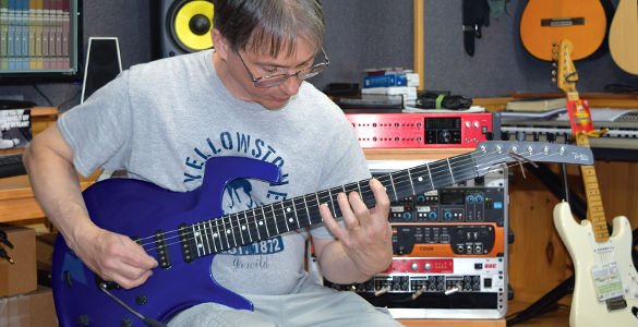 Bill playing guitar in the studio